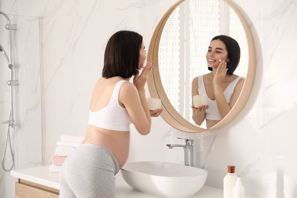 Young,Pregnant,Woman,With,Cosmetic,Product,In,Bathroom