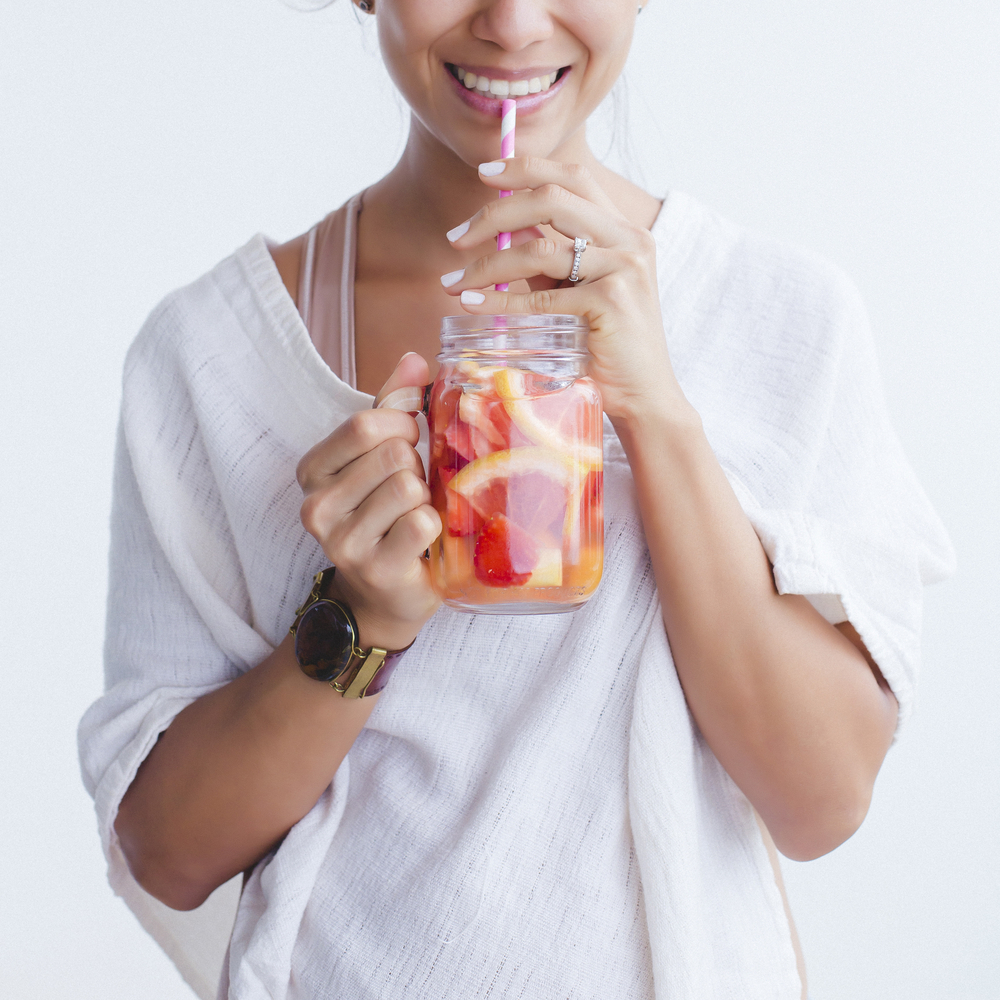 Woman,Drinking,An,Orange,And,Grapefruit,Infused,Water,In,Mason
